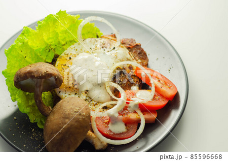 The fried portion of gammon served with egg, fresh lettuce, tomato, onion and funguses 85596668