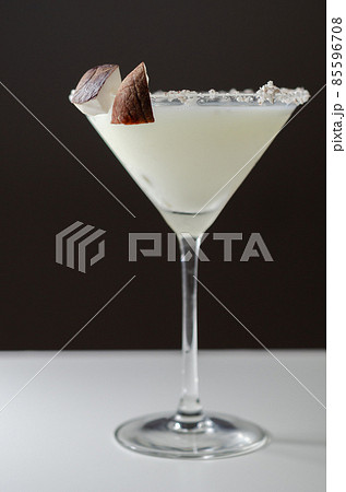 Coconut cocktail in martini glass based on the rum decorated with coconut flakes and coconut pieces Coconut cocktail in martini glass based on the rum decorated with coconut flakes and coconut pieces 85596708
