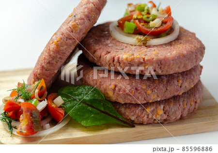 Raw beef burgers blended with caramelised red onion and tangy red Leicester cheese prepared for grilling 85596886