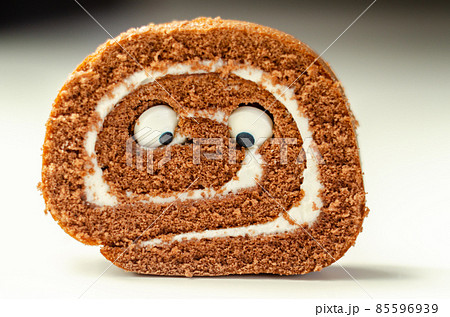 Chocolate sponge roll with a vanilla flavour filling with decorating sweet eyes, chocolate swiss roll 85596939