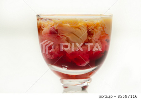 Interesting drink shot based on cream, liqueur and grenadine called Brain Hemorrhage prepared for Halloween party 85597116