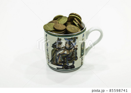 coins in the decorated antique ceramic tea cup 85598741