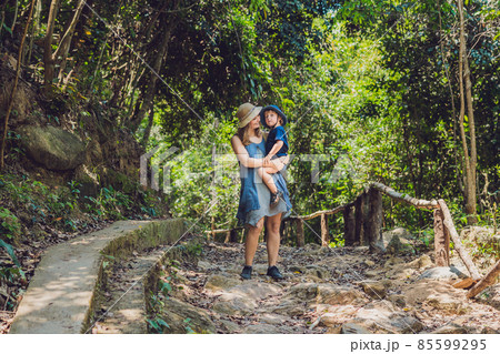 Mom and son are walking on the forest road Mom and son are walking on the forest road 85599295