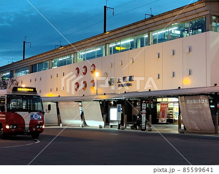 夕暮れの新幹線の駅舎。バスロータリーでばすが待機する 85599641