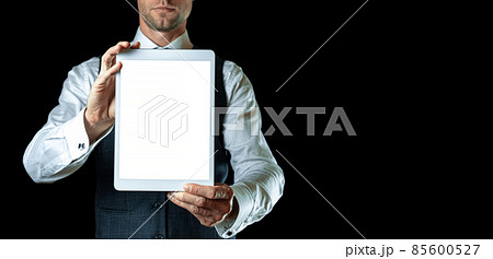 Screen mockup. Empty blank tablet in businessman hand. Mock up screen smart device isolated on black banner background. Game design, mobile application presentation or portfolio mockups. Screen mockup. Empty blank tablet in businessman hand. Mock up screen smart device isolated on black banner background. Game design, mobile application presentation or portfolio mockups. 85600527
