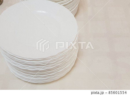 White clean empty plates in a stack on the table, service in the hotel cafe 85601554