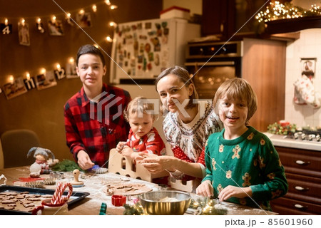 Family with three kids cooking ginger cookies. Merry Christmas, Happy New Year. Family time Family with three kids cooking ginger cookies. Merry Christmas, Happy New Year. Family time 85601960