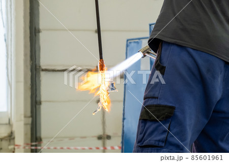 A man uses a gas burner to melt glass. A craftsman makes a glass in a leaf shaped. A man uses a gas burner to melt glass. A craftsman makes a glass in a leaf shaped. 85601961
