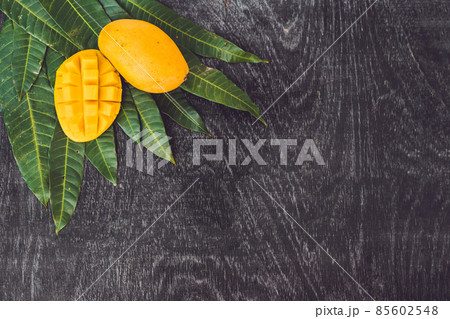 Mango and mango leaves on an old wooden background 85602548