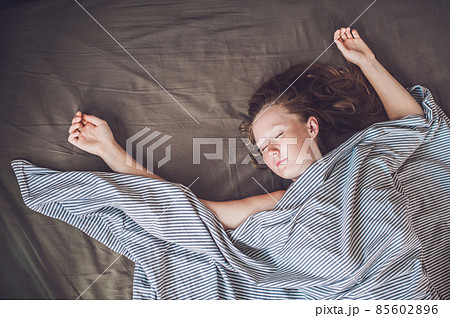 Beautiful young woman lying down in bed and sleeping, top view. Do not get enough sleep concept 85602896