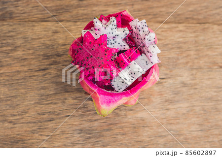 Pieces of sliced dragon fruit in the form of a star on an old withered background Pieces of sliced dragon fruit in the form of a star on an old withered background 85602897