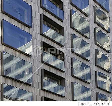 reflections in the mirrored windows of a modern building 85603205