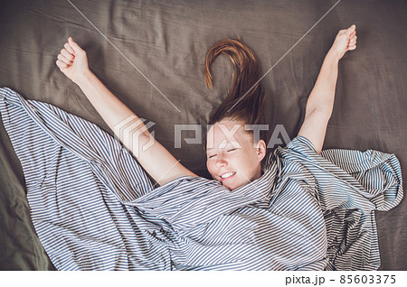 Beautiful young woman lying down in bed and sleeping, top view. Do not get enough sleep concept 85603375