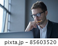 Serious german man executive dressed in formal clothes looking at laptop screen browsing internet 85603520
