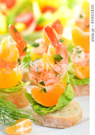 Scampi skewers with mandarin on Italian bread Scampi skewers with mandarin on Italian bread 85603830