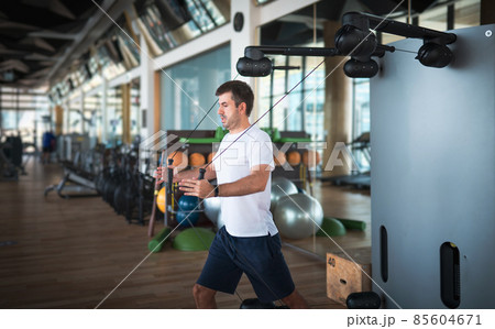 Man exercising in the gym on a pec deck machine for chest workout 85604671