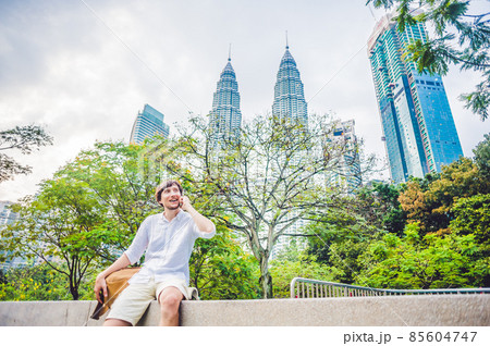 Young Man on the phone. Dressing in a white shirt, beige shorts. Mobile Office concept 85604747