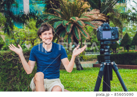 Young man blogger records video in front of the camera in the park 85605090