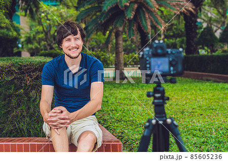 Young man blogger records video in front of the camera in the park 85605236