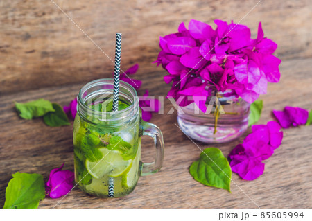 Spring purple flowers and spring mojito drink on an old wooden background 85605994