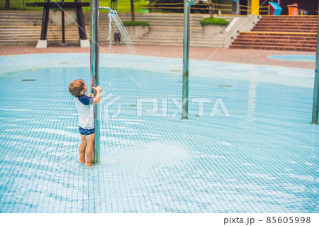 Boy playing in the paddling pool in the summertime 85605998