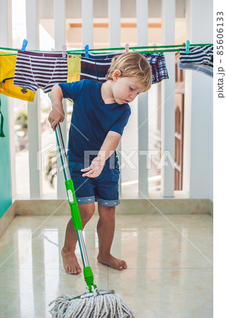 kid boy cleaning room, washing floor with mop. Little home helper kid boy cleaning room, washing floor with mop. Little home helper 85606133