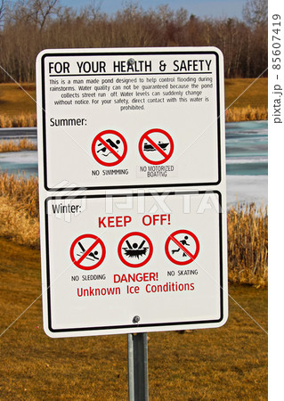 Warning signs around storm drainage pond 85607419
