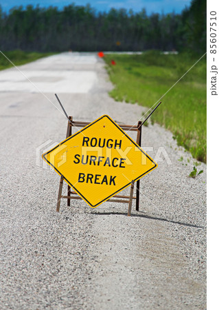 A yellow rough surface break sign with a road blurring into the background A yellow rough surface break sign with a road blurring into the background 85607510