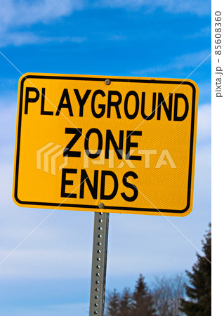 Playground Zone End Sign Against Blue Cloudy Sky and Trees Playground Zone End Sign Against Blue Cloudy Sky and Trees 85608360