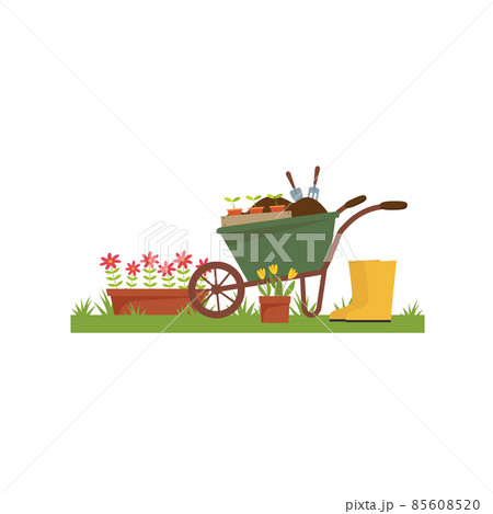 Spring landscape in the garden with green grass, flower, garden wheelbarrow, shovel. Spring landscape in the garden with green grass, flower, garden wheelbarrow, shovel. 85608520