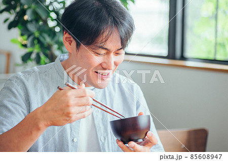 温かい汁を飲む男性（味噌汁、スープ） 85608947