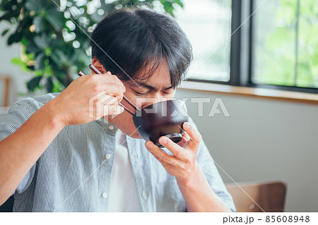 温かい汁を飲む男性（味噌汁、スープ） 85608948