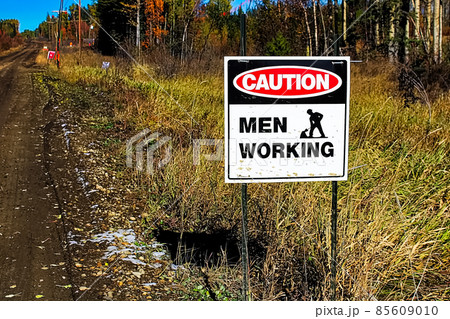 A caution men working sign beside a road 85609010