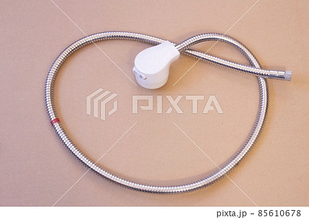 日本のシャワーホースの部品、床に置いたヘッドとメタルのホース 85610678