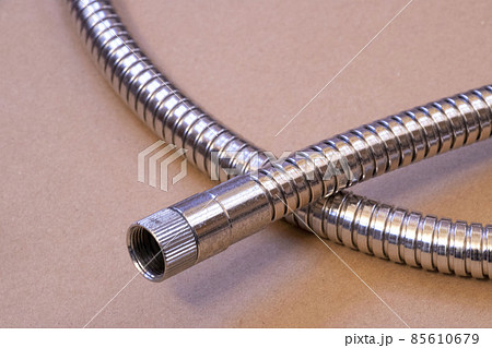 日本のシャワーホースの部品、メタルのホースの口のアップ左向き 85610679