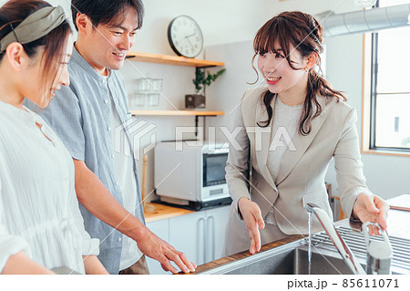 キッチンの設備を説明する女性(水道) キッチンの設備を説明する女性(水道) 85611071