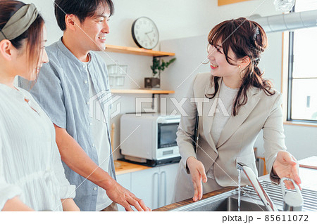 キッチンの設備を説明する女性(水道) キッチンの設備を説明する女性(水道) 85611072