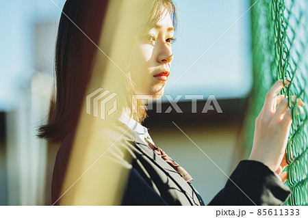 フェンス側で佇む女子高生 85611333