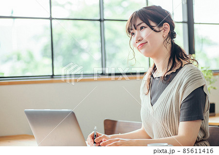 おしゃれ空間で勉強する女性（笑顔） 85611416
