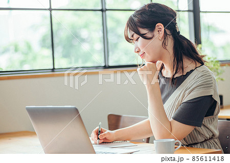 おしゃれ空間で勉強する女性（笑顔） 85611418