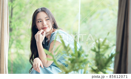 緑の植物を背景にくつろぐ女性 ボタニカルイメージ 緑の植物を背景にくつろぐ女性 ボタニカルイメージ 85612071