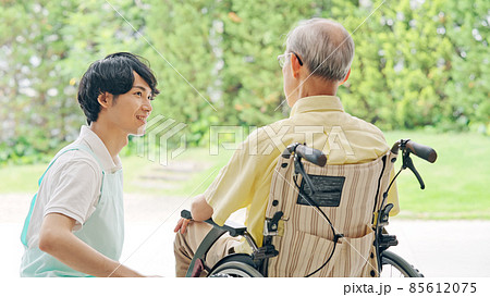 車いすに乗ったお年寄りと介護ヘルパー 85612075