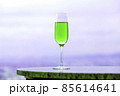 紫グレーの風景に溶け込む緑のシャンペングラスとコピースペース 85614641