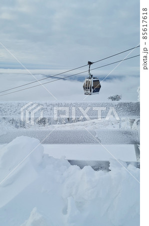 Empty white red closed ski lift cabin no people and white dramatic snowy mountains background. End of season concept. Ski resorts closure Empty white red closed ski lift cabin no people and white dramatic snowy mountains background. End of season concept. Ski resorts closure 85617618