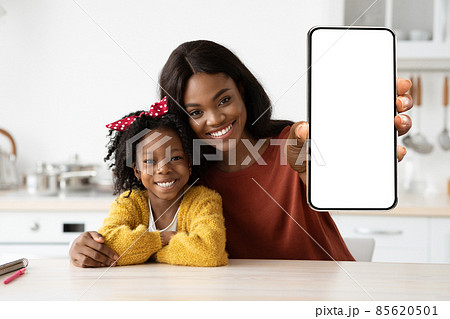 Mobile Ad. Smiling Black Mom And Daghter Showing Big Blank Smartphone Mobile Ad. Smiling Black Mom And Daghter Showing Big Blank Smartphone 85620501