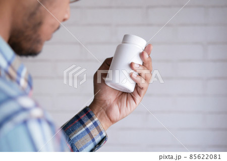 young man hand holding medicine pill container  85622081