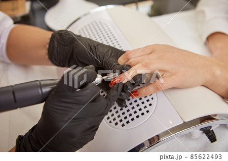 Professional manicurist removing shellac from woman nails Professional manicurist removing shellac from woman nails 85622493