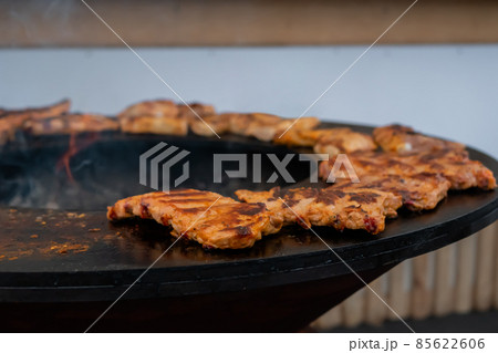 Process of cooking meat steaks on round brazier - close up Process of cooking meat steaks on round brazier - close up 85622606