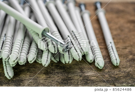 Close up shooting of parts of carpentry screws with cross head. Screws on the table. Industrial background Close up shooting of parts of carpentry screws with cross head. Screws on the table. Industrial background 85624486