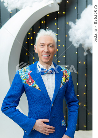 A man in a blue suit smiles with white hair suit blue studio success standing, for businessman shirt in job elegance confidence, confident portrait. Intelligence serious hand, attitude A man in a blue suit smiles with white hair suit blue studio success standing, for businessman shirt in job elegance confidence, confident portrait. Intelligence serious hand, attitude 85625075